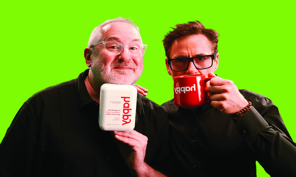 Robert Downey Jr. drinking from a mug that says happy and Craig Dubitsky holding a pod of Happy coffee.