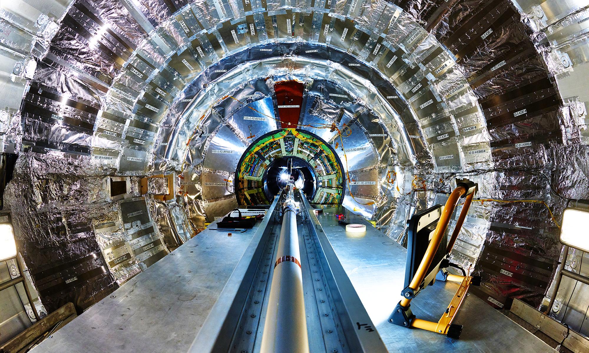 欧洲核子十大赌博正规老平台中心的CMS探测器内部, showing a large central beam pipe surrounded by a silver cylinder of detectors.